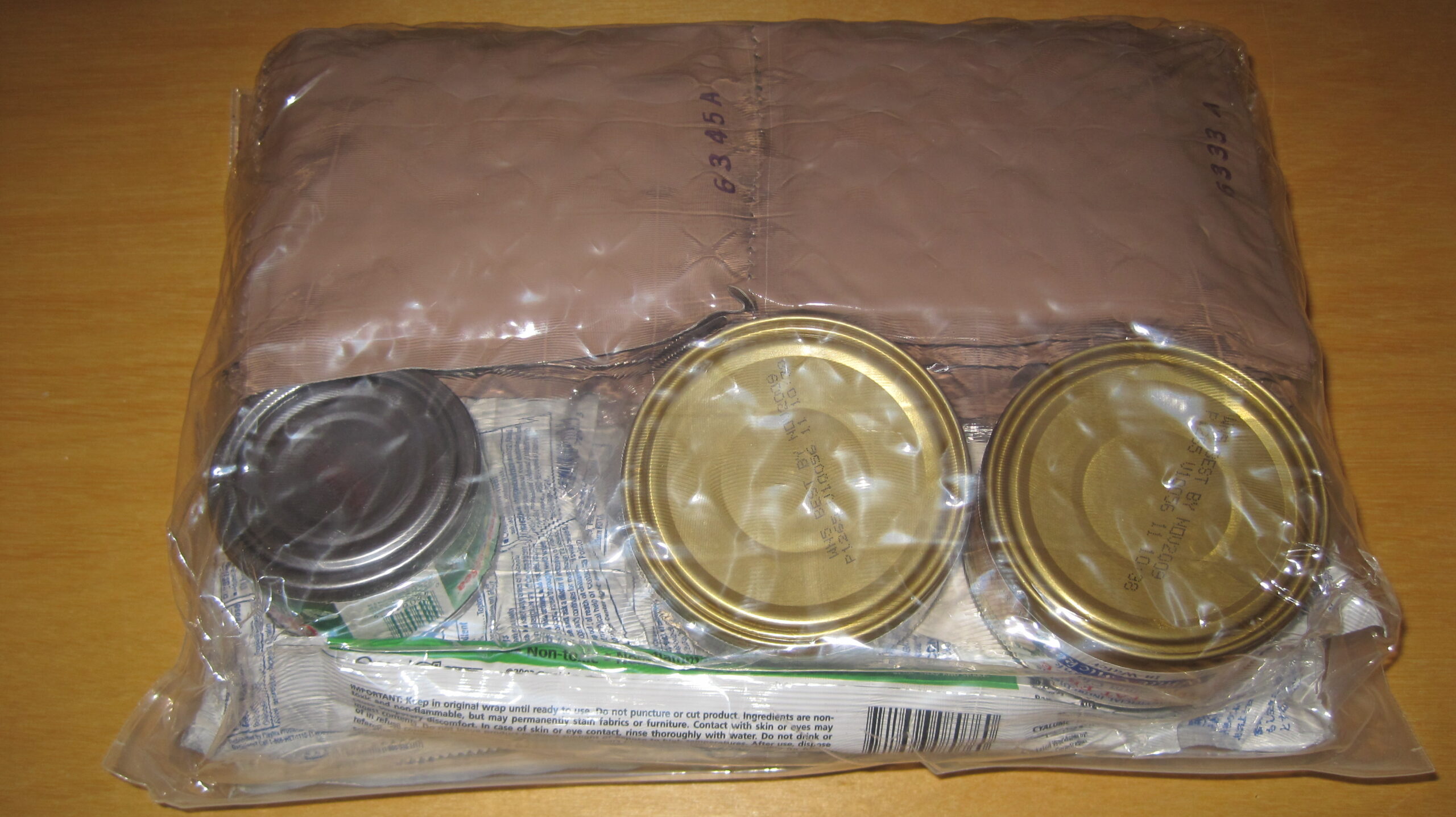 A person organizing a survival kit with dry bags to ensure effective emergency go bag weatherproofing.